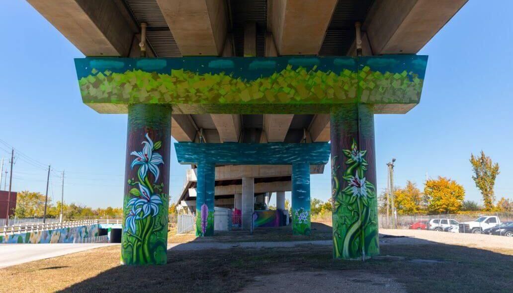 Mural of flowers and leaves under the elevated train tracks across from Main Street at the Burnett Transit Center